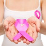 Woman holding a pink cancer awareness ribbon